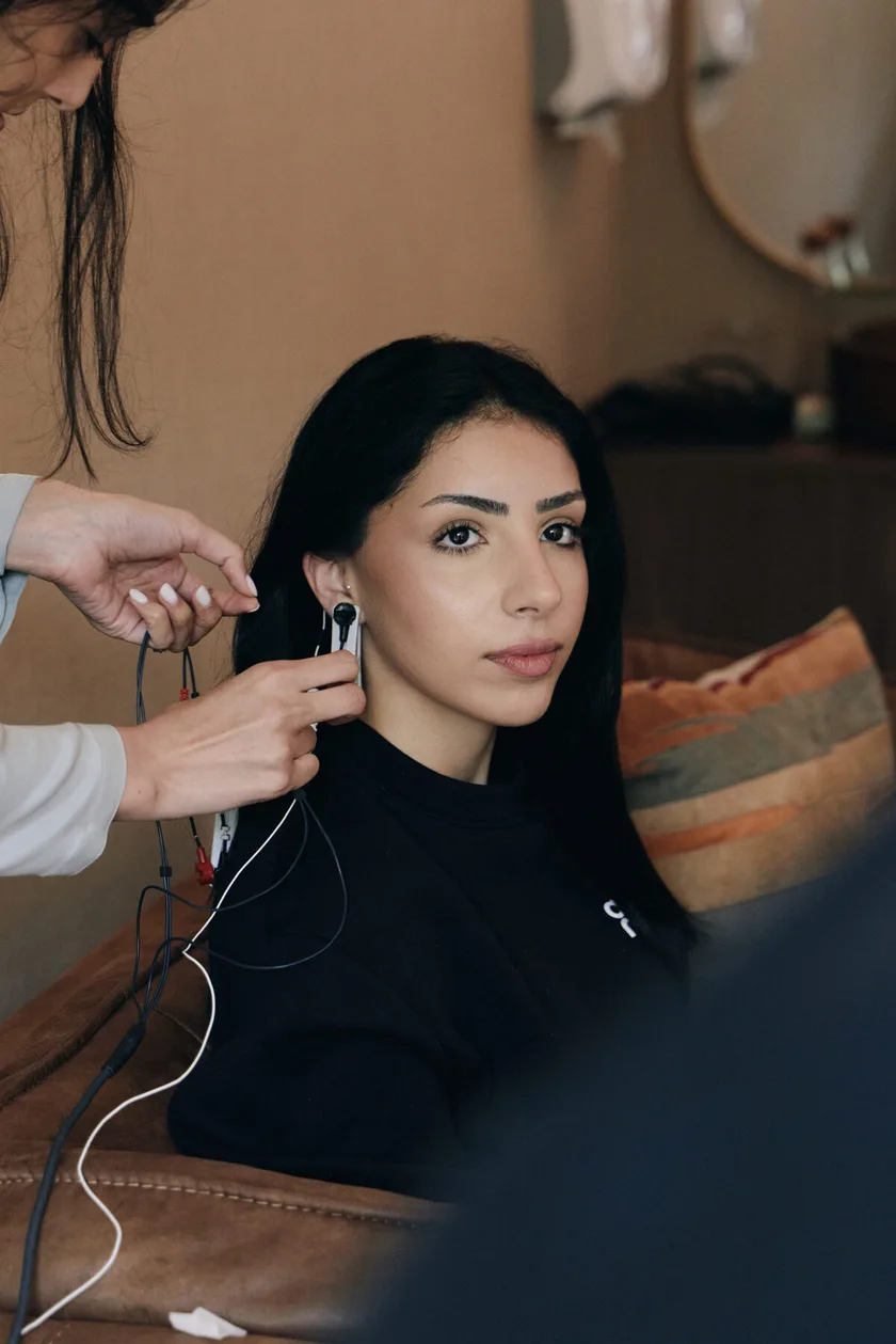 Sensors being placed beside a client's ear before a session